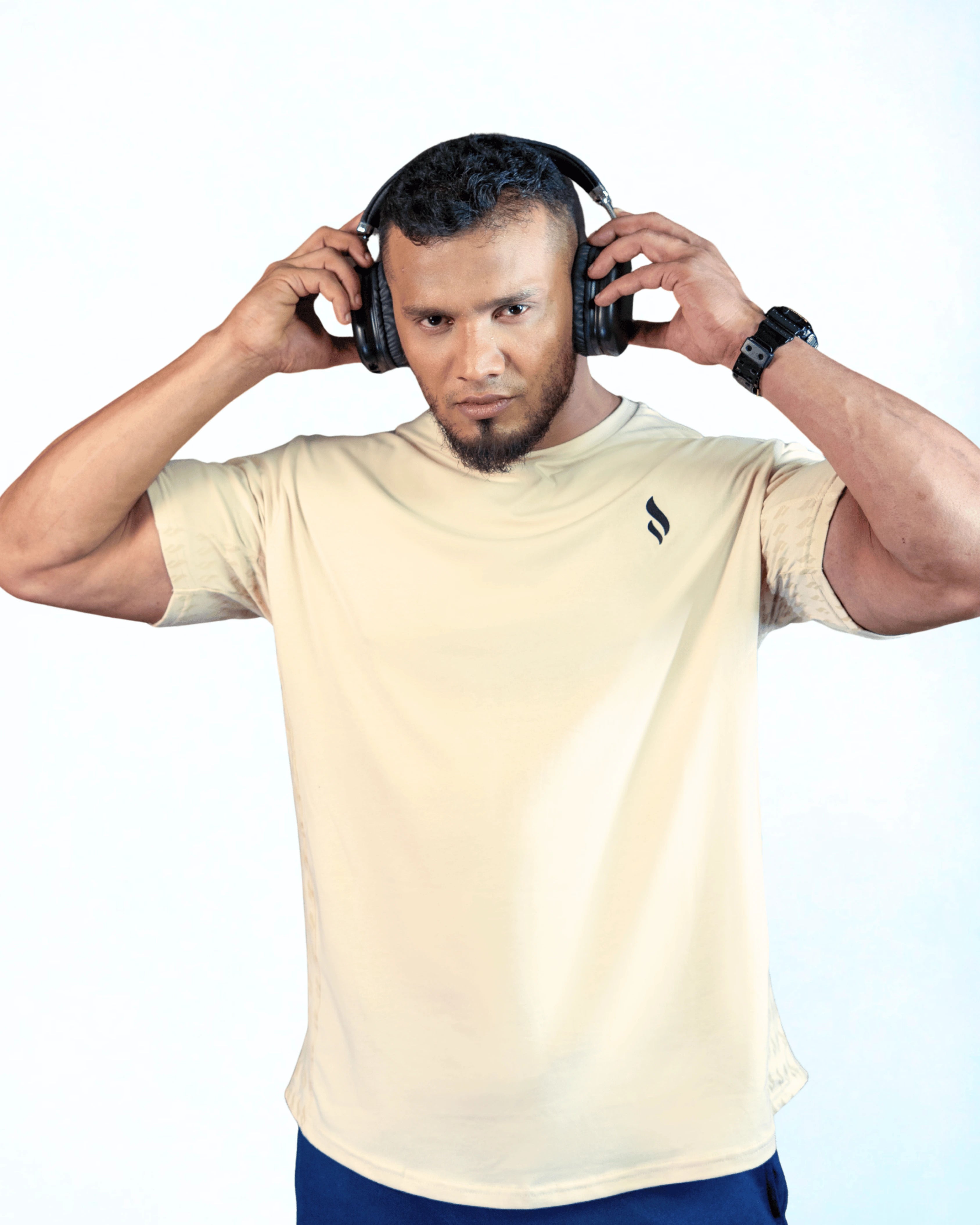 Man wearing headphones and a beige t-shirt on a white background