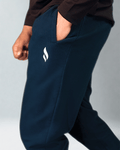Navy blue jogger pants with a logo on a gray background